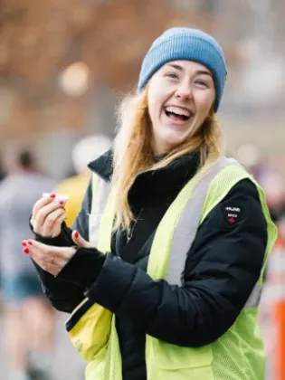 NYRR volunteer laughing at a race