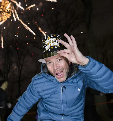 Runner in a New Year hat celebrating under fireworks