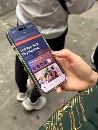 Holding a phone showing the TCS New York City Marathon tracking screen