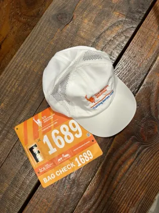 Training series cap and marathon bag check bib on a wood table